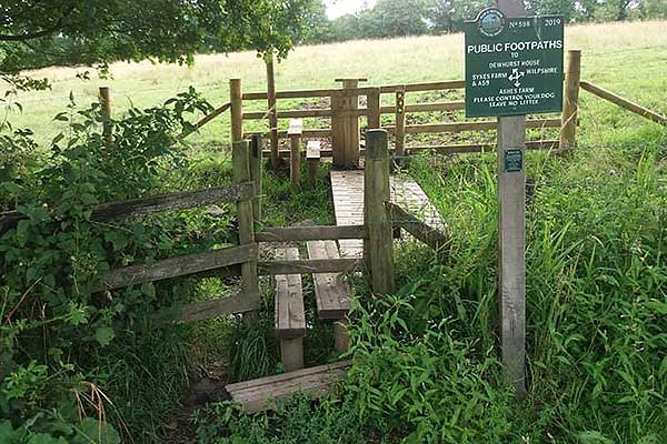New boardwalk over a wide muddy ditch with two new stiles.